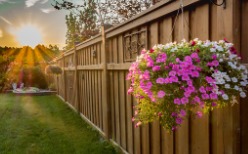 A wood fence with flowers hanging on it, installed by a Fence Company in Peoria IL