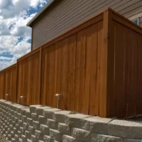 A wood privacy fence set on stone bricks