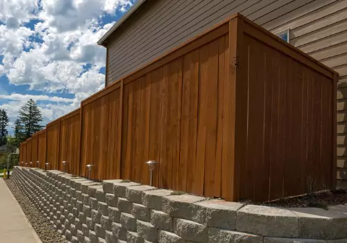 A wood privacy fence set on stone bricks